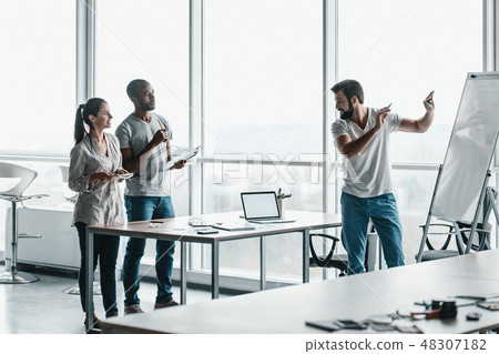 Team of three co-workers in stylish studio 48307182