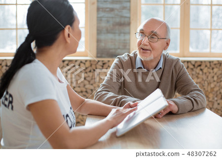 Volunteer and gay senior man sharing impressions Volunteer and gay senior man sharing impressions 48307262