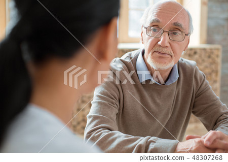 Volunteer and serious senior man having conversation Volunteer and serious senior man having conversation 48307268
