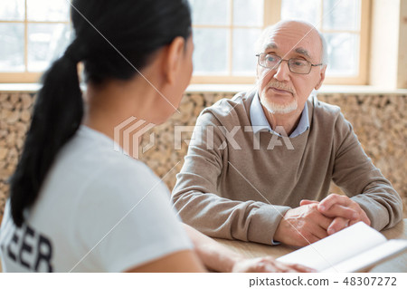 Volunteer and appealing senior man talking about book Volunteer and appealing senior man talking about book 48307272