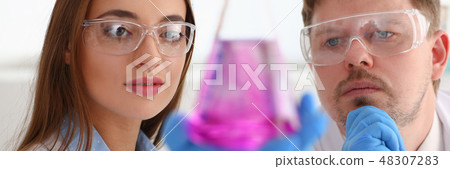 Technician hold in arms in protective gloves sample bottle 48307283