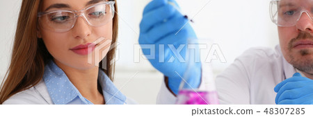 Technician hold in arms in protective gloves sample bottle 48307285