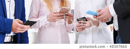 Group of people look at phones in arms at Group of people look at phones in arms at 48307668