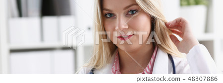 Beautiful smiling female doctor sit at workplace Beautiful smiling female doctor sit at workplace 48307886