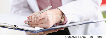 Male doctor arm hold silver pen filling patient Male doctor arm hold silver pen filling patient 48307888