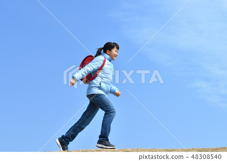 Girl running in the blue sky (school bag) 48308540