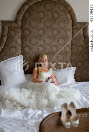 Young sexy blonde woman in bedroom sitting on bed Young sexy blonde woman in bedroom sitting on bed 48309486