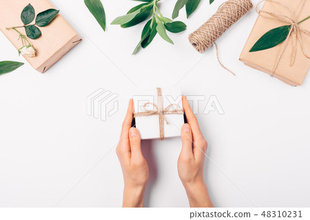 Woman's hands holding small gift box Woman's hands holding small gift box 48310231