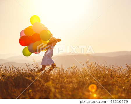 . happy child with balloons at sunset in summer . happy child with balloons at sunset in summer 48310479