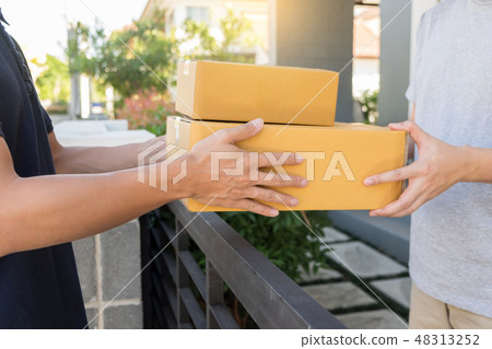 Home delivery service delivers package at home and woman receivi 48313252
