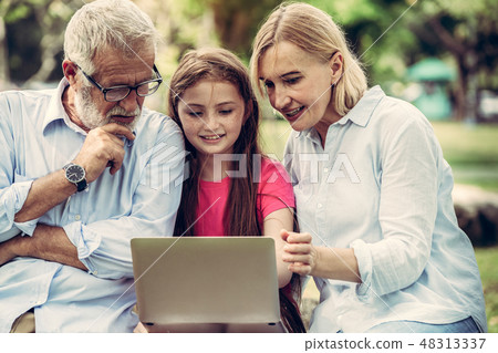 Happy family using laptop computer in public park. Happy family using laptop computer in public park. 48313337