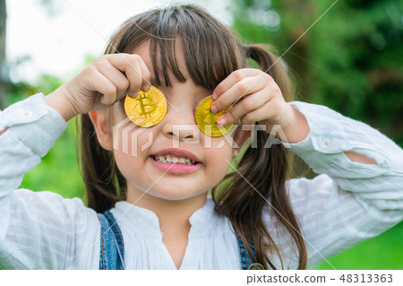 Little girl kid holding bitcoin digital money. 48313363