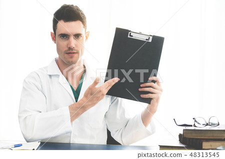 Doctor working in hospital office. 48313545