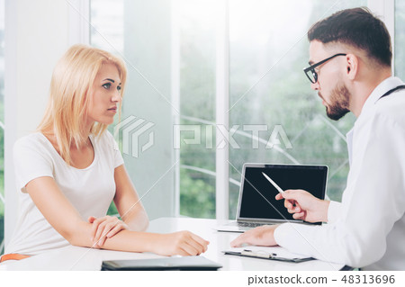 Male Doctor and Female Patient in Hospital Office 48313696
