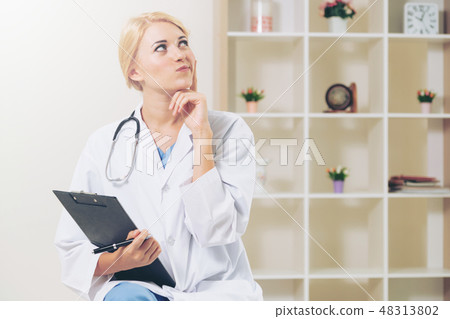 Young female doctor working in hospital office. Young female doctor working in hospital office. 48313802