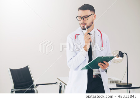 Doctor holding patients health file in hospital. 48313843