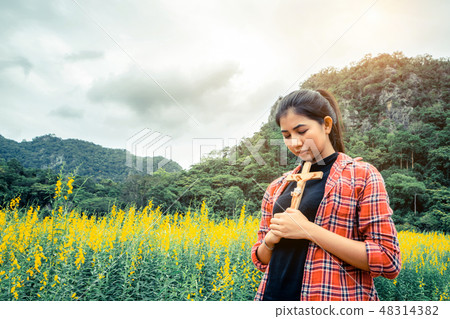 Young beautiful woman praying on nature background 48314382