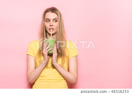 Cute young woman drinking a green smoothie 48316253
