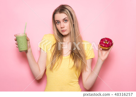 Cute young woman drinking a green smoothie 48316257