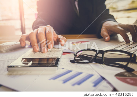 Businessman or accountant working on calculator to Businessman or accountant working on calculator to 48316295