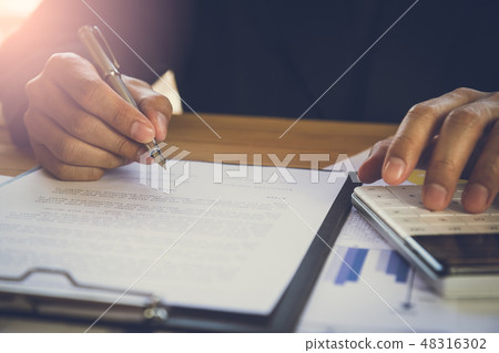 Businessman or accountant working on calculator to Businessman or accountant working on calculator to 48316302