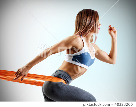 Young sporty woman using a resistance band. 48323200