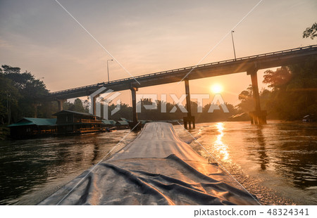 Sailing long-tail boat with sunrise on bridge 48324341