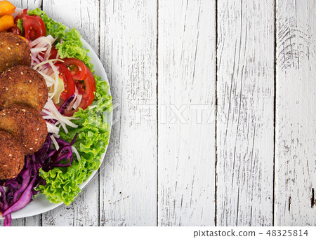 Falafel plate with fresh vegetables, hummus and french fries. Falafel plate with fresh vegetables, hummus and french fries. 48325814