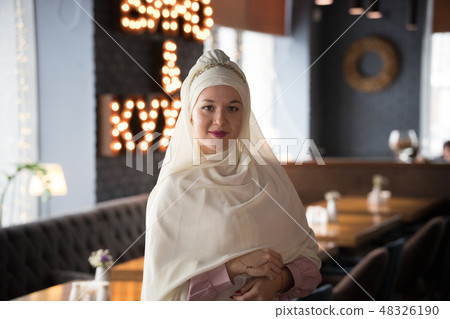 A young muslim woman in hijab standing in the cafe 48326190