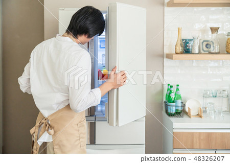 A man who opens a refrigerator A man who opens a refrigerator 48326207