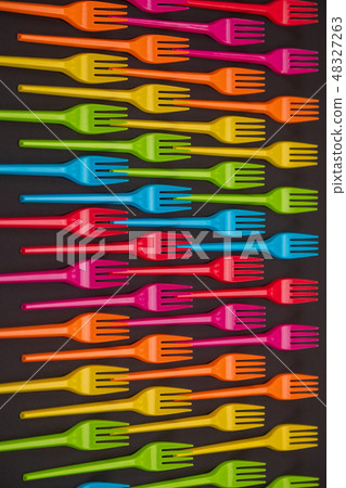 Many color plastic forks on a bright background Many color plastic forks on a bright background 48327263