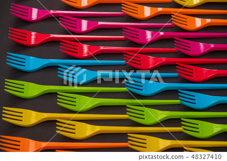 Many color plastic forks on a bright background Many color plastic forks on a bright background 48327410