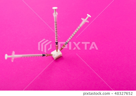 white medical syringes stick out of a piece of sugar 48327652