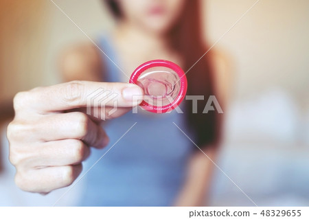 Condom ready to use in female hand, give  48329655