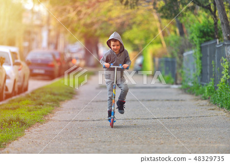 Boy with scooter having fun in the park 48329735