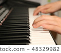 A hand playing a piano 48329982