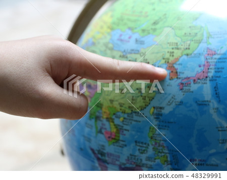 A finger pointing to a globe A finger pointing to a globe 48329991
