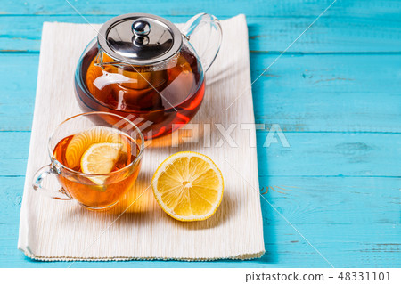 Glass cup of tea with lemon and glass teapot. 48331101