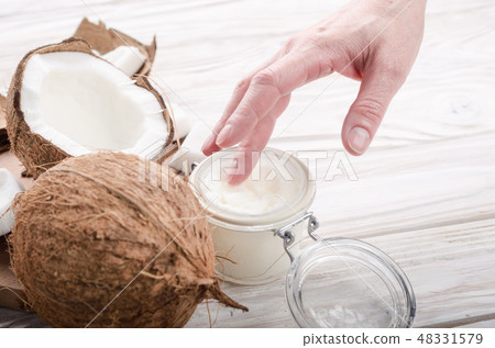 Coconut oil on human palm and in airtight glass Coconut oil on human palm and in airtight glass 48331579