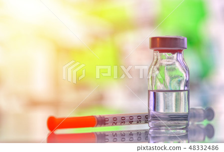 Closeup of vaccine bottle with syringe and needle 48332486