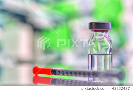 Closeup of vaccine bottle with syringe and needle 48332487