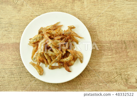 crispy fried anchovy fish with salt on plate 48332522