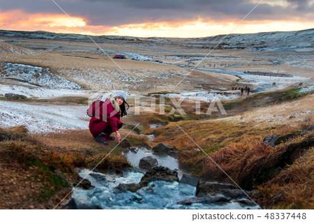 Female traveler by a thermal river in Iceland 48337448