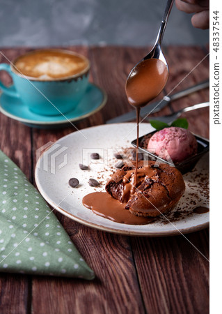 Chocolate lava cake Molten with ice cream on plate and cappuccino. Balls of ice cream in cup . Dark 48337544