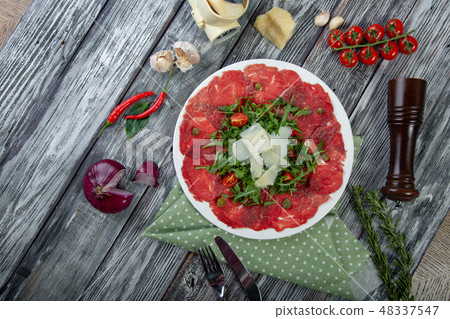 close-up carpaccio meat with arugula and slices of parmesan cheese close-up carpaccio meat with arugula and slices of parmesan cheese 48337547