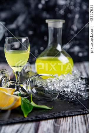 Italian typical digestive limoncello with fresh lemons in smoke, selective focus 48337682