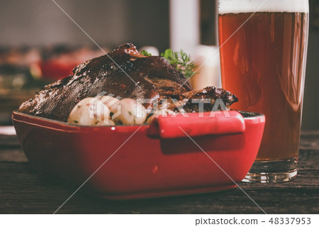 Close up roast pork knuckle served with boiled potatoes and glass of beer Close up roast pork knuckle served with boiled potatoes and glass of beer 48337953