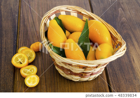 Ripe sweet orange kumquats fortunella in wooden 48339834