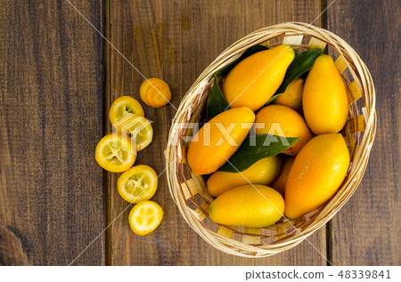 Ripe sweet orange kumquats fortunella in wooden 48339841