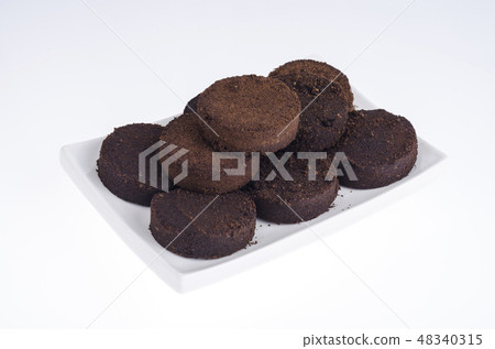 Pressed waste coffee beans on white background Pressed waste coffee beans on white background 48340315